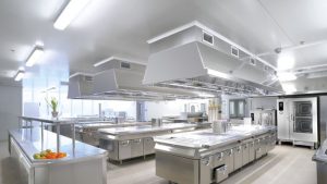 uma cozinha industrial bem iluminada com luminárias led