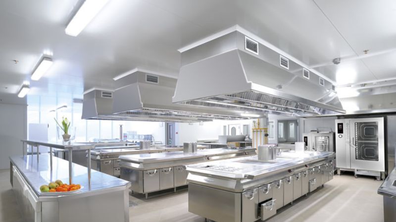 uma cozinha industrial bem iluminada com luminárias led