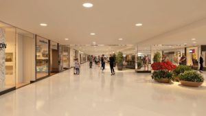 Corredor de lojas em um shopping iluminado por luminárias high bay