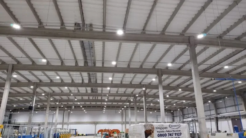 Foto interna de um galpão industrial que utiliza iluminação high bay