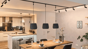 luminária pendente em trilho iluminando uma mesa na sala de jantar 