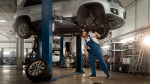 homem consertando um carro em uma oficina mecânica  